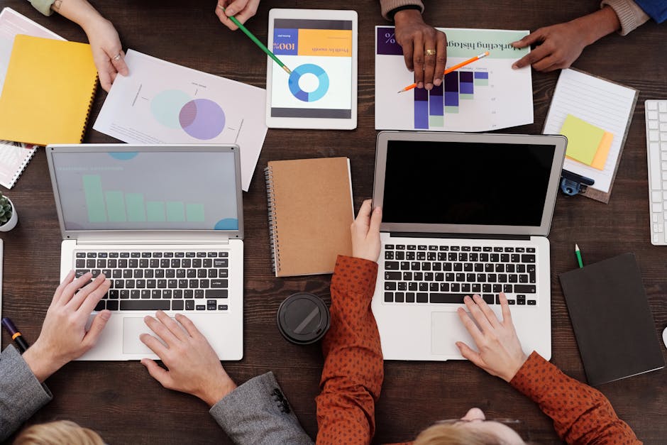 Overhead view of a team discussing digital marketing strategies with laptops and charts